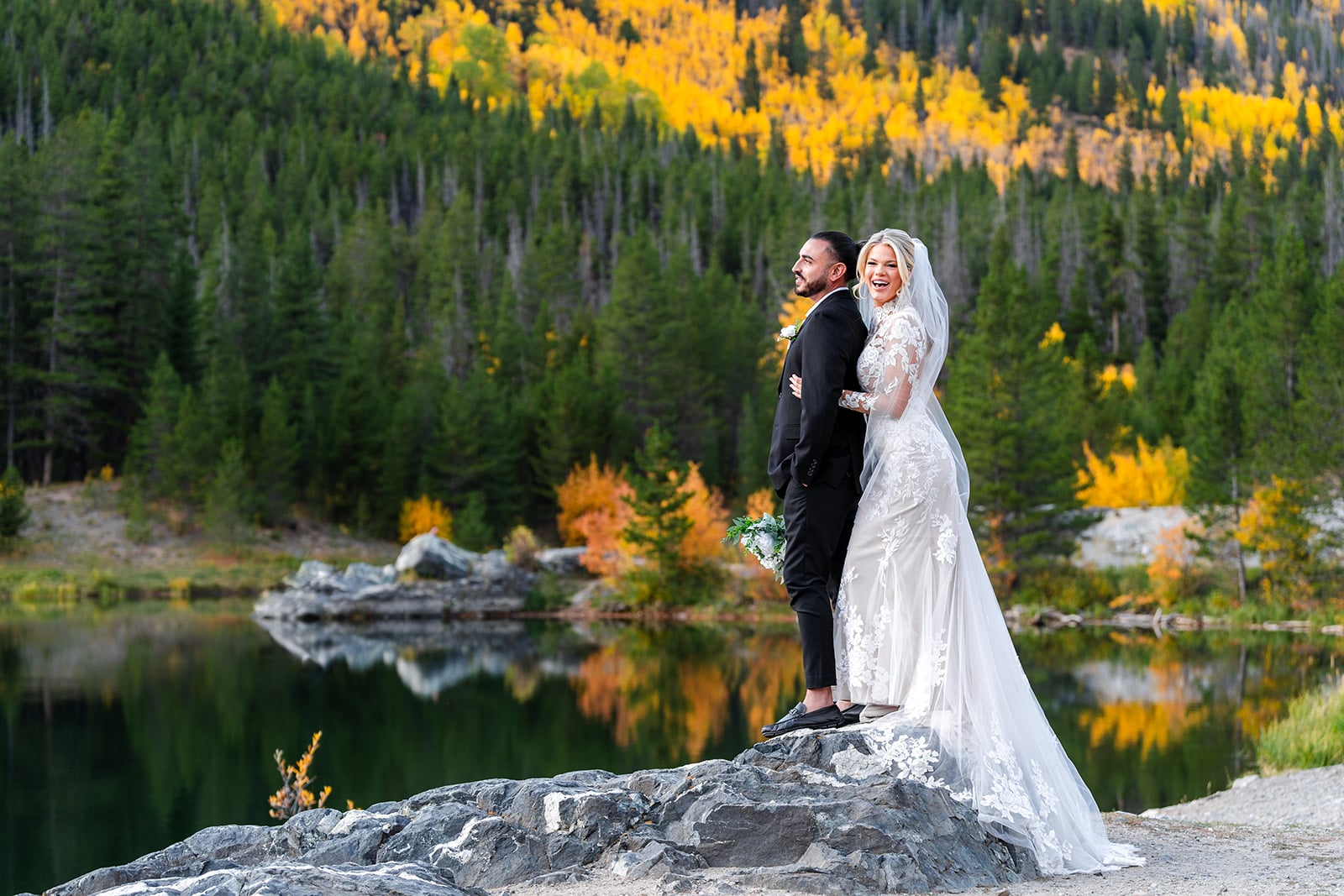 Wedding couple celebrating by alpine lake in Colorado Fall