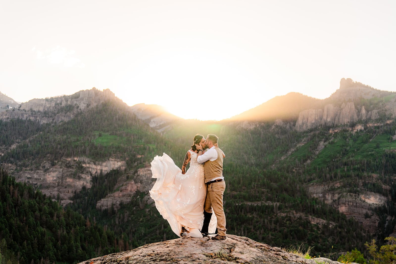 circular profile photo of a bride and groom embracing on a mountain cliff