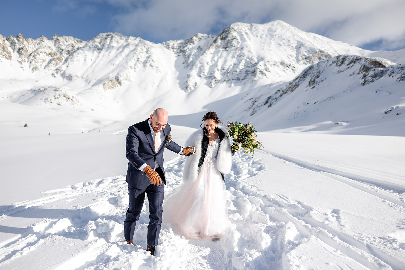 Winter elopement in Colorado -snow-dusted pines, cozy wraps, and joyful portraits against snowy mountain peaks.