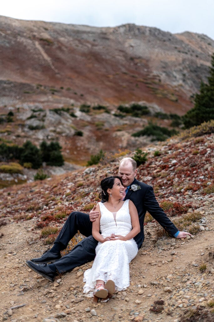 Couple sitting on rocky terrain.